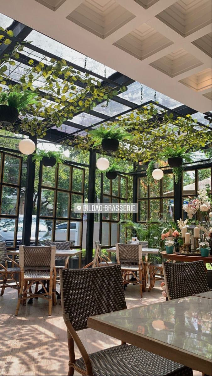 an outdoor dining area with lots of tables and chairs under a pergolated roof