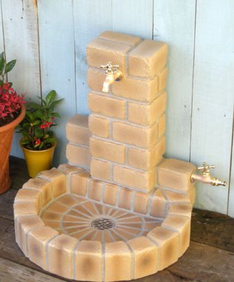 a water fountain made out of bricks on the ground