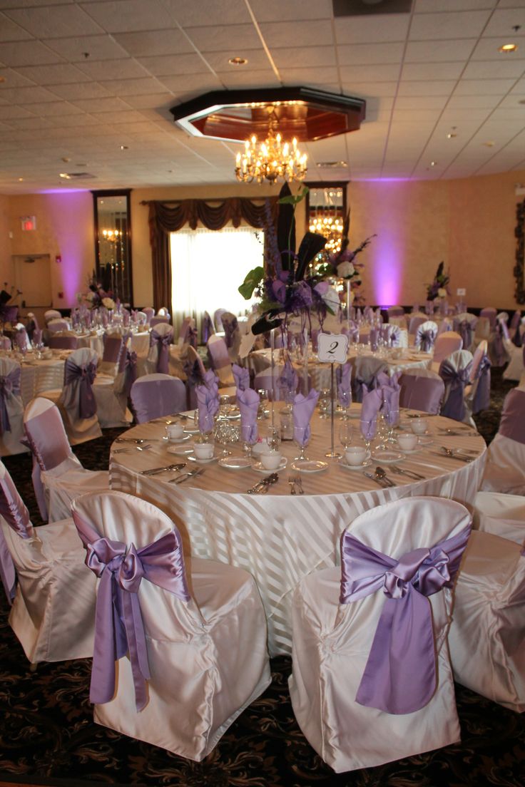 the banquet room is set up with purple sashes and white linens for chairs