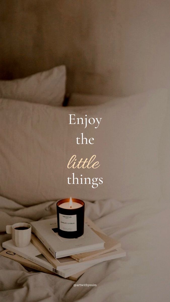 a candle and some books on a bed with the words enjoy the little things above it