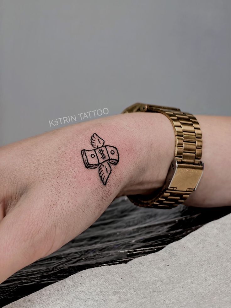 a person's foot with a tattoo on the left side of their leg, and a gold bracelet around her wrist