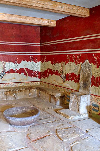 a bathroom with red and white wallpaper, stone sink and toilet