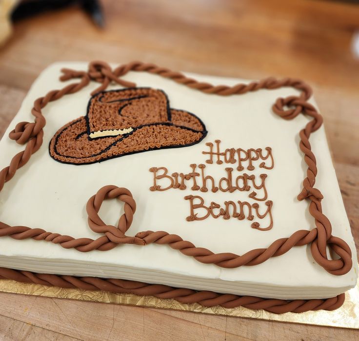 a birthday cake with the words happy birthday bunny written on it and a cowboy hat