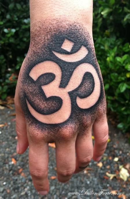 a person's hand with an om shan tattoo on it