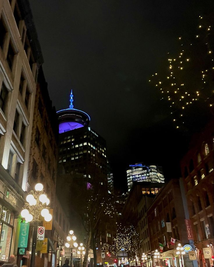 a city street filled with lots of traffic and tall buildings covered in lights at night