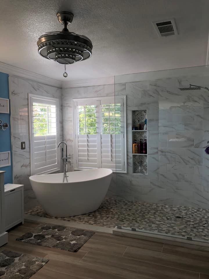 a large white bath tub sitting inside of a bathroom next to a walk in shower