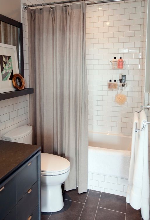 a white toilet sitting next to a bath tub in a bathroom on top of a tiled floor