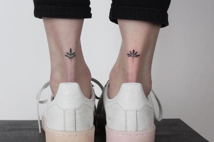 a woman's feet with two small tattoos on them