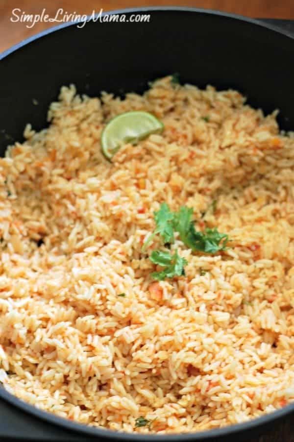 mexican rice in a skillet with cilantro and lime