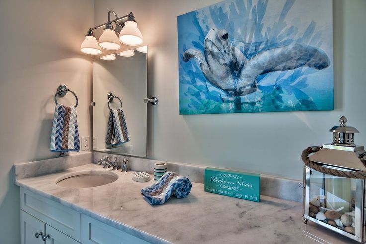 a bathroom with marble counter tops and blue towels hanging on the wall next to it