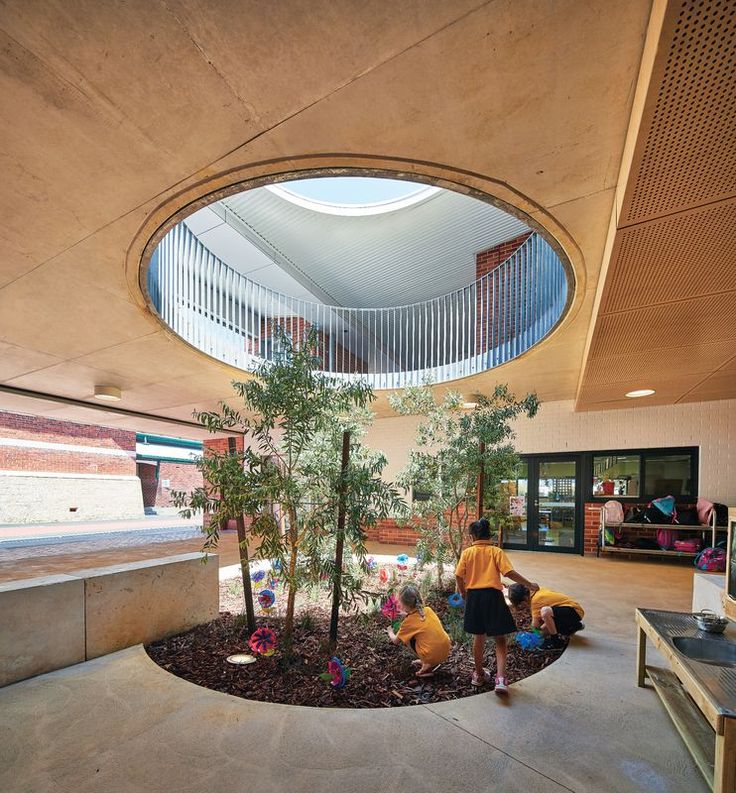 two people are sitting in the middle of a room with a circular window above them