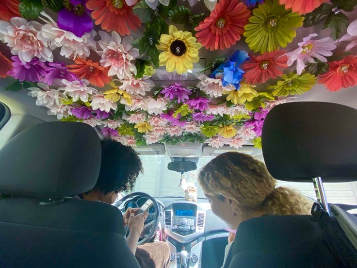 two people in a car with flowers on the ceiling