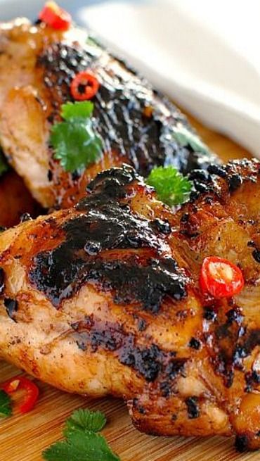 two pieces of chicken on a cutting board with garnishes and parsley