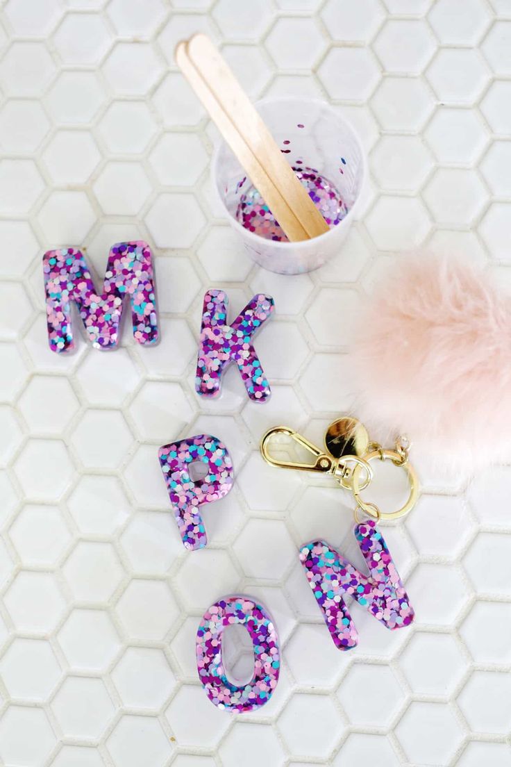 the word mom spelled out with pink and blue confetti on a white tiled surface