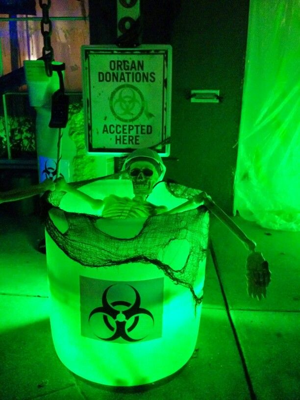 a green light filled bucket with a biohazard sign on it