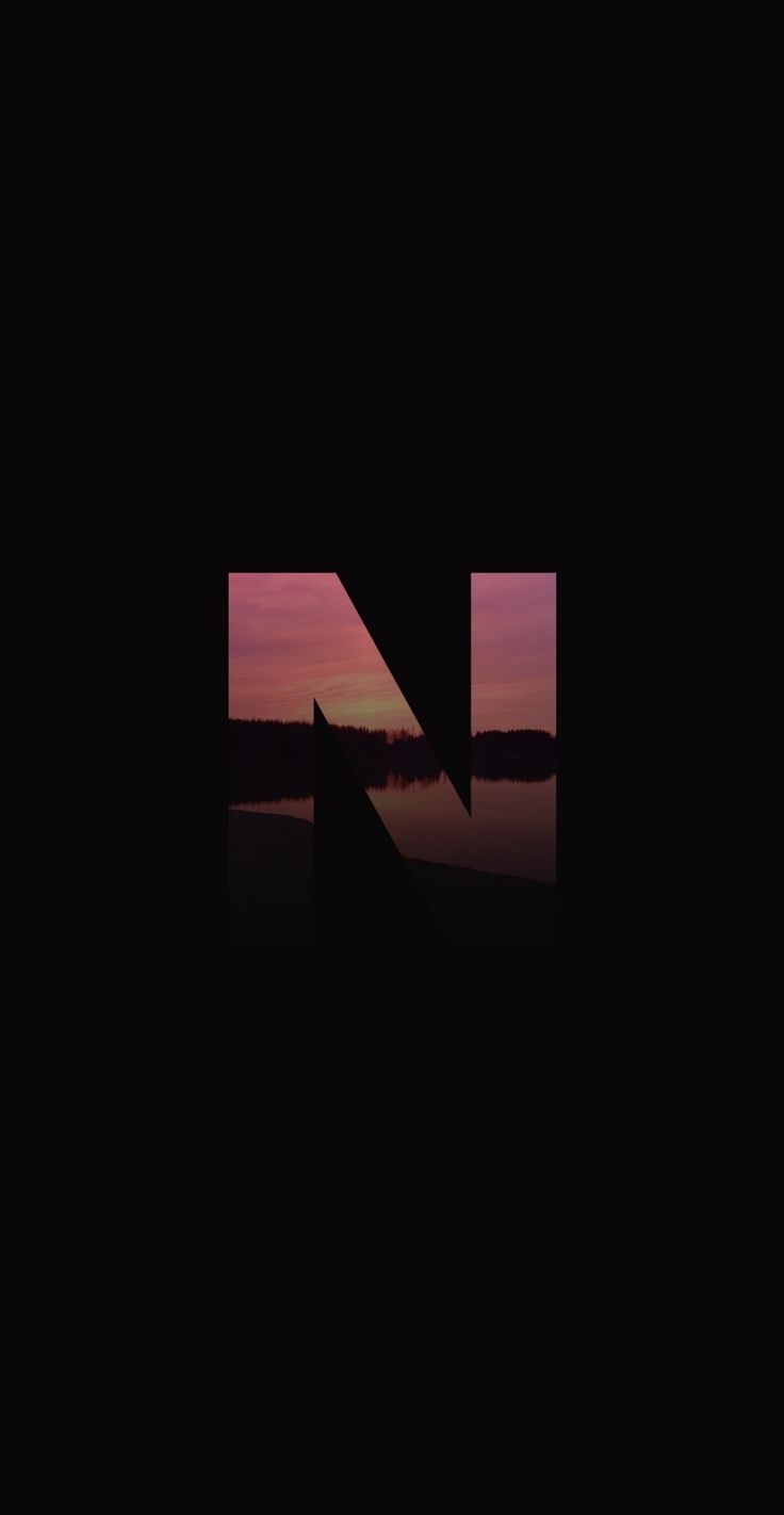 the letters n and n are reflected in water at sunset, with an arrow pointing to the right