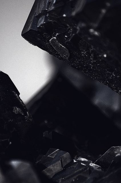 a black and white photo of some sort of rock or metal structure with small pieces of glass embedded in it