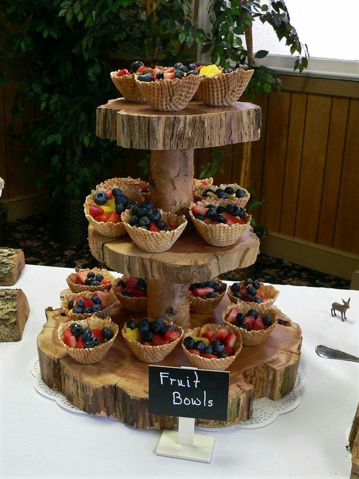 there is a three tiered fruit bowl display on the table