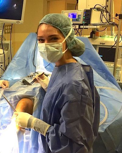 a woman in scrubs is sitting in the operating room