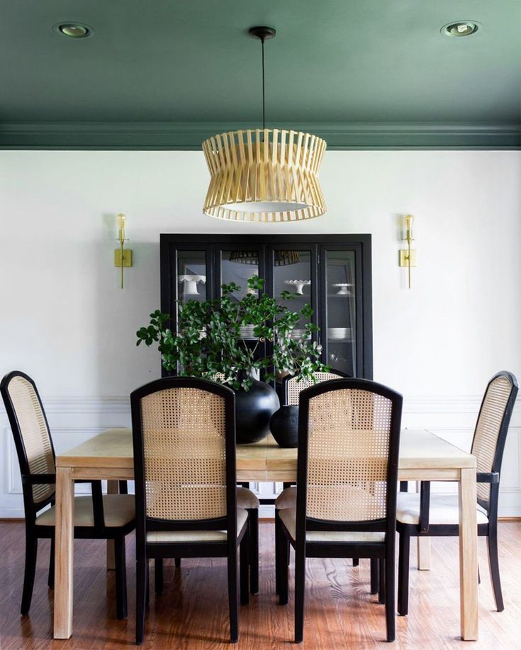 a dining room table with chairs and a potted plant on top of the table