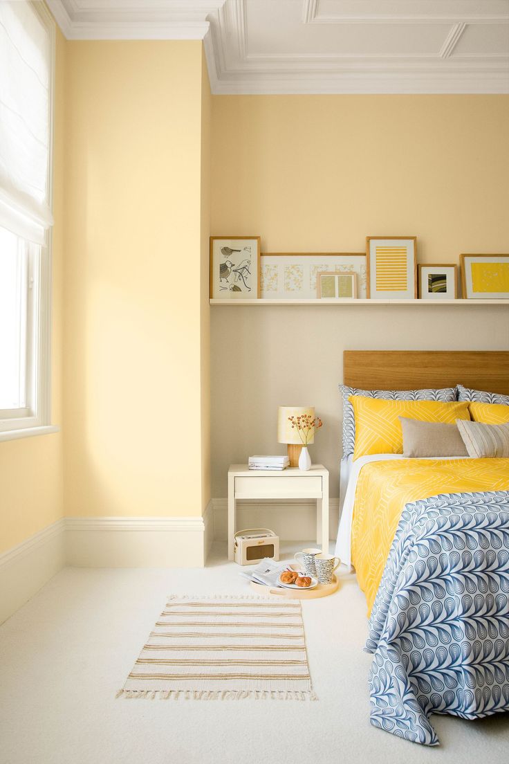 a bedroom with yellow walls and white floors