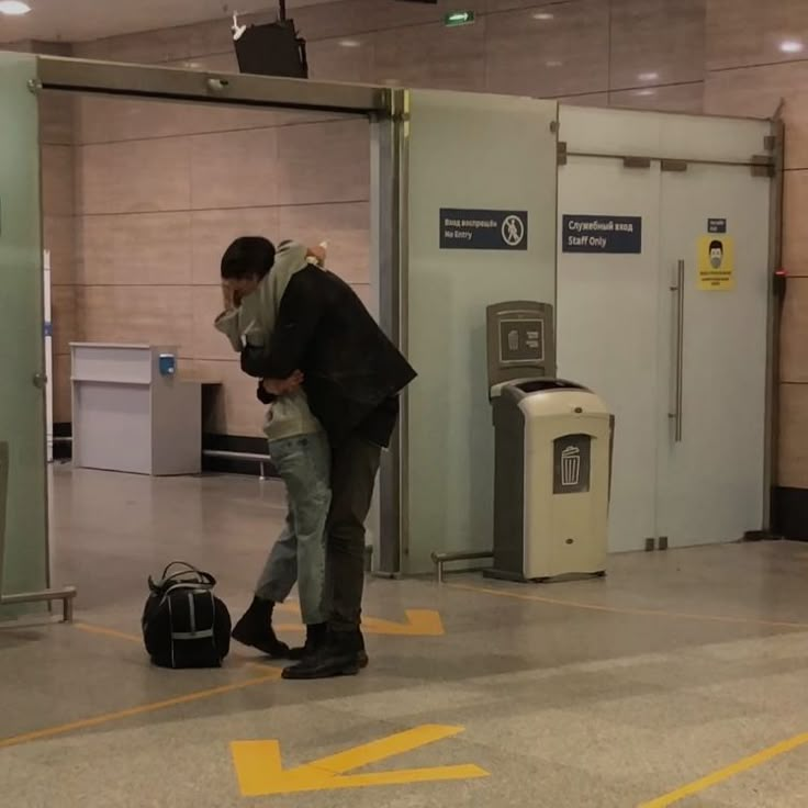 a man standing in an airport with his luggage