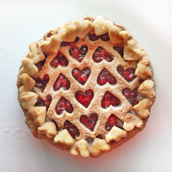 a heart shaped pie on top of a white table with hearts cut out of it