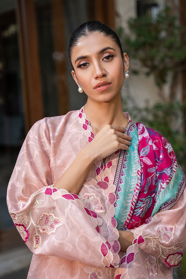 A blush pink cotton net kurta is adorned with scalloped embroidery along the neckline and sleeves and leaf motifs in a mulberry hue. A painterly printed mulberry hued medium silk dupatta is paired with a matching rawsilk trousers. Pink Long Sleeve Raw Silk Anarkali Set, Pink Silk Palazzo Set With Chikankari Embroidery, Pink Cotton Silk Palazzo Set For Eid, Pink Silk Long Sleeve Anarkali Set, Long Sleeve Pink Silk Anarkali Set, Pink Long Sleeve Silk Anarkali Set, Pink Raw Silk Palazzo Set With Chikankari Embroidery, Pink Floral Embroidery Cotton Silk Sets, Pink Raw Silk Kurta With Floral Embroidery