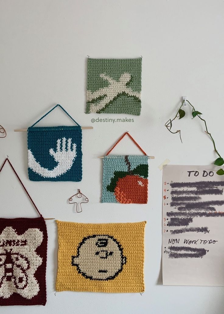 there are many small crocheted pictures hanging on the wall