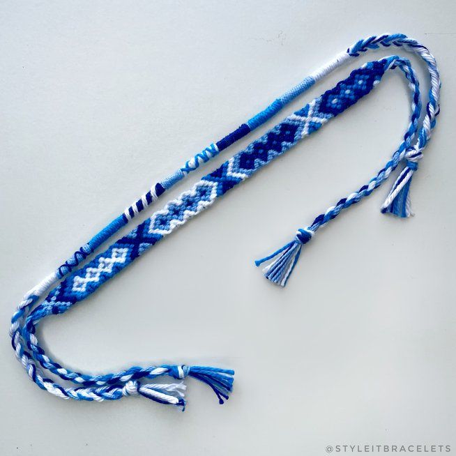 a blue and white string with tassels on it