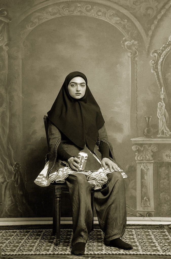 an old photo of a woman sitting on a chair