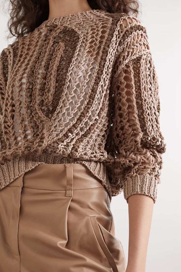 a woman is wearing a brown sweater and tan pants