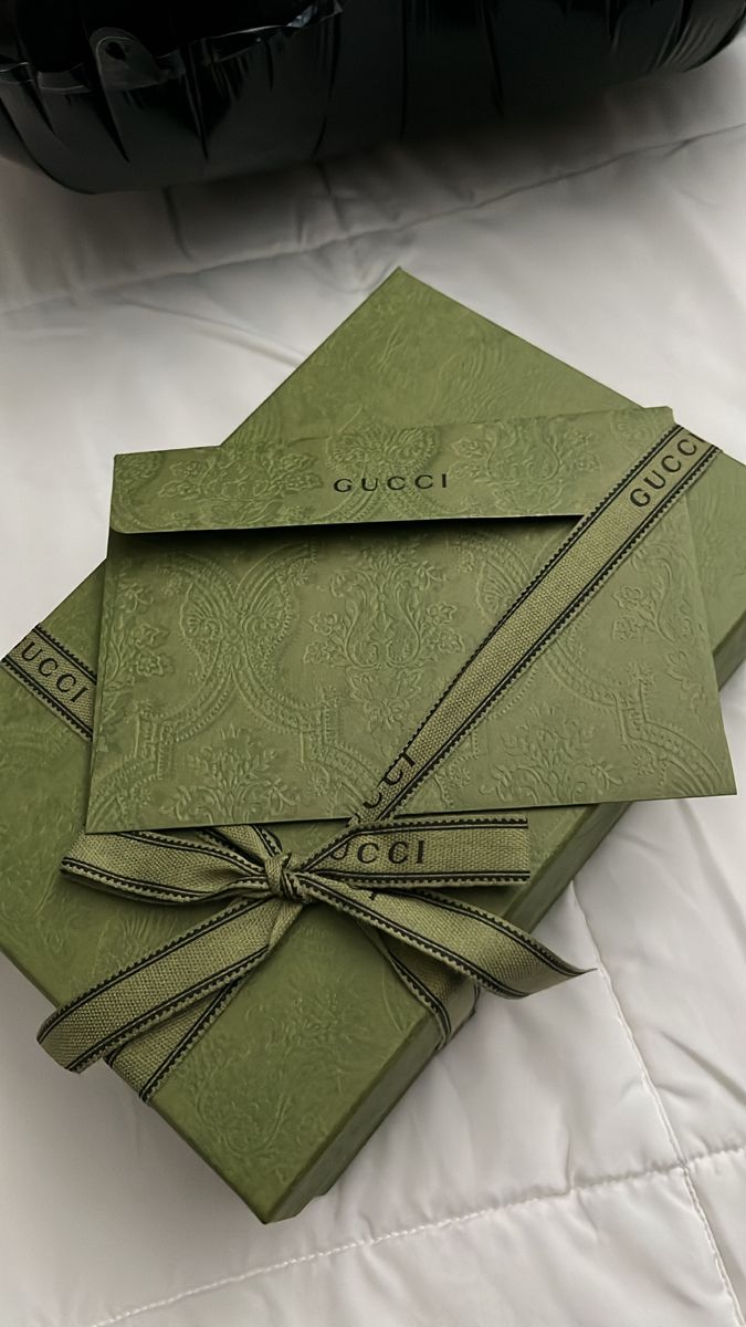 three green envelopes tied together on a bed