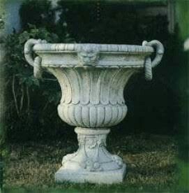 a large white urn sitting in the grass