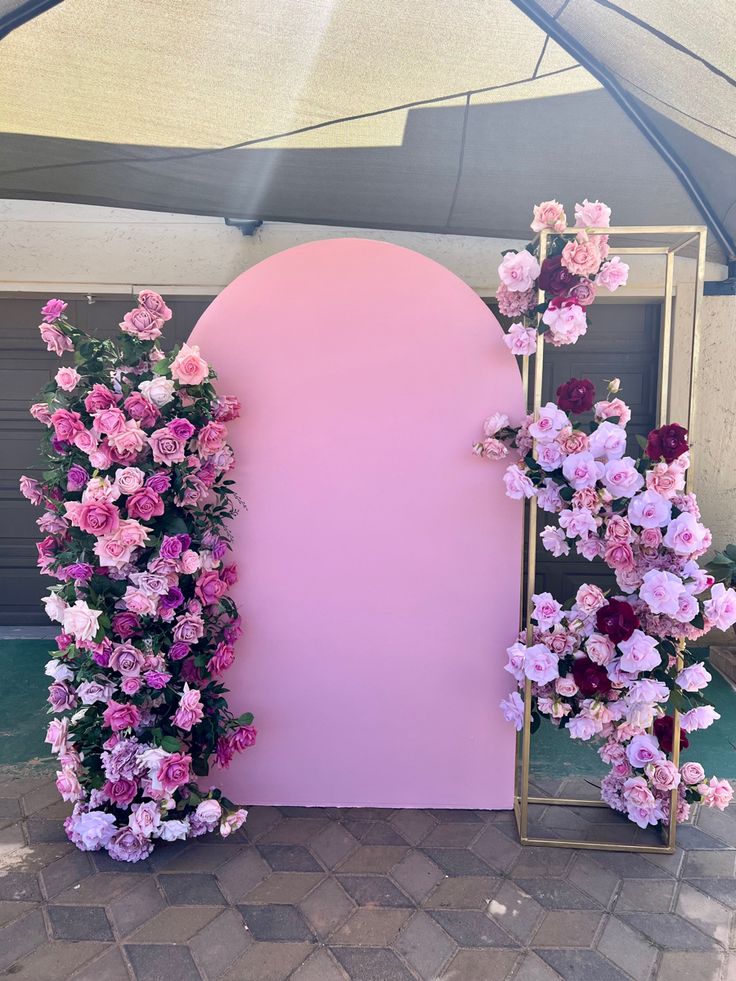 a pink arch with flowers on it