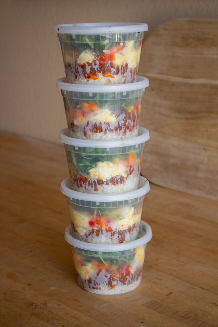 four plastic containers with food in them stacked on top of each other and one is empty