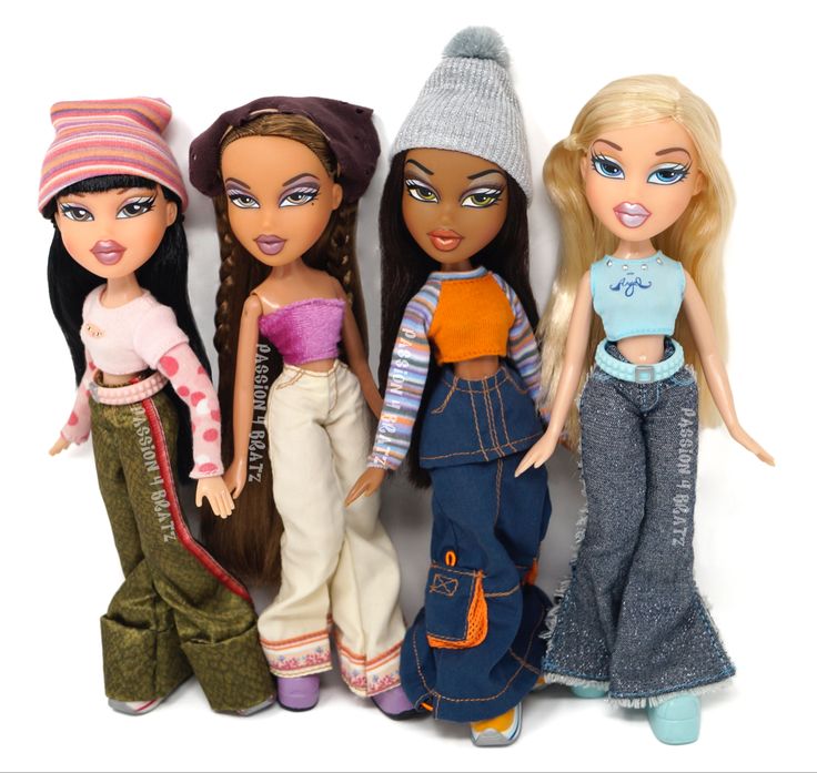 four dolls are standing next to each other on a white surface, one is wearing jeans and the other has a hat