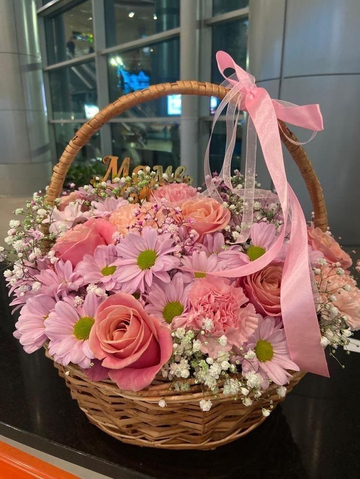 a basket filled with pink flowers on top of a table