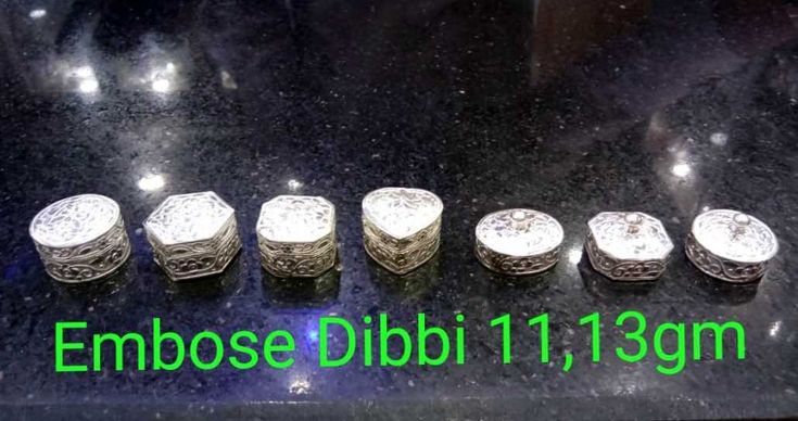 five silver rings sitting on top of a black counter next to the words embose dubai