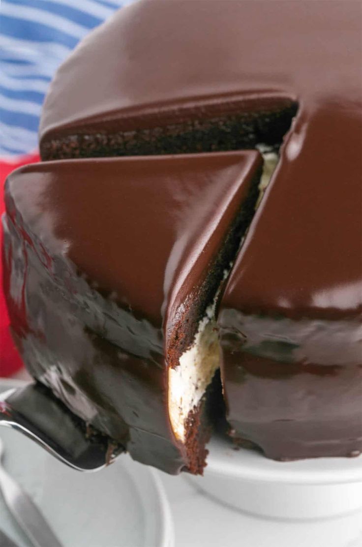 a piece of chocolate cake on a white plate with a slice taken out of it