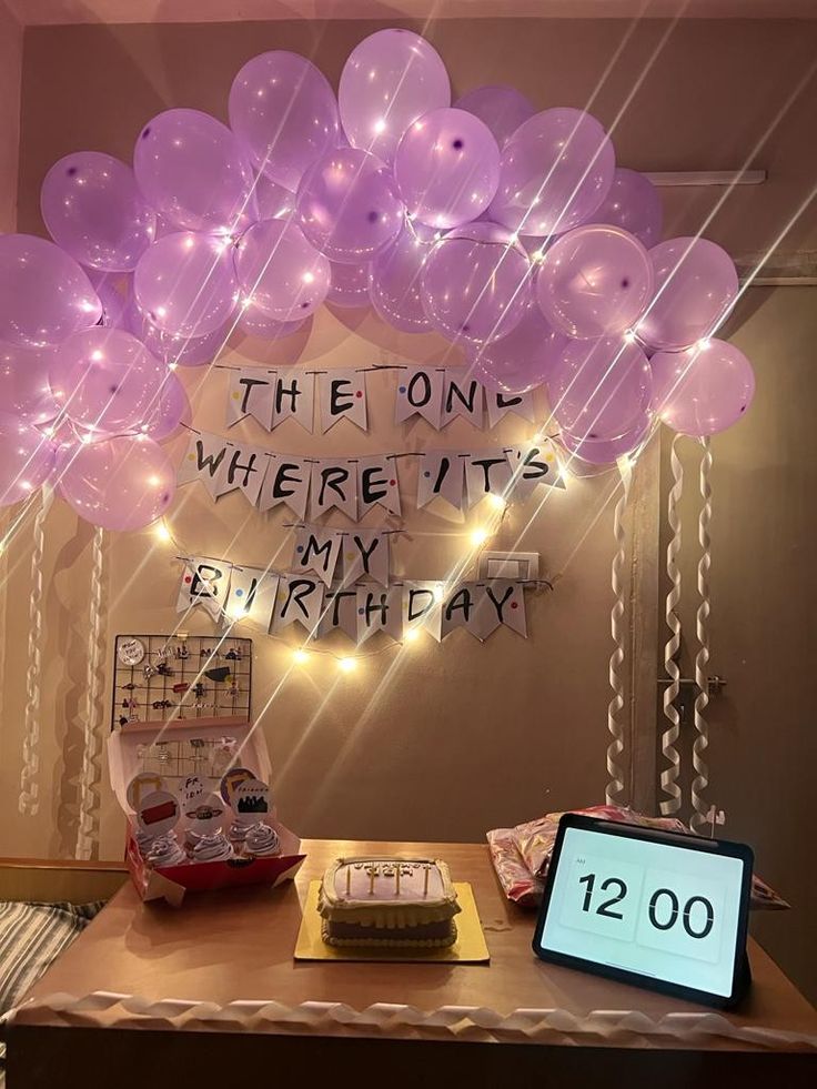 a table topped with balloons and a sign that says the one where it's my birthday