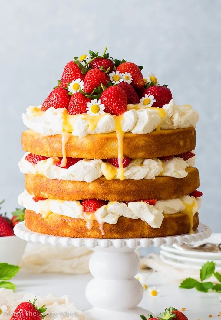 a strawberry lemonade cake with fresh strawberries on top