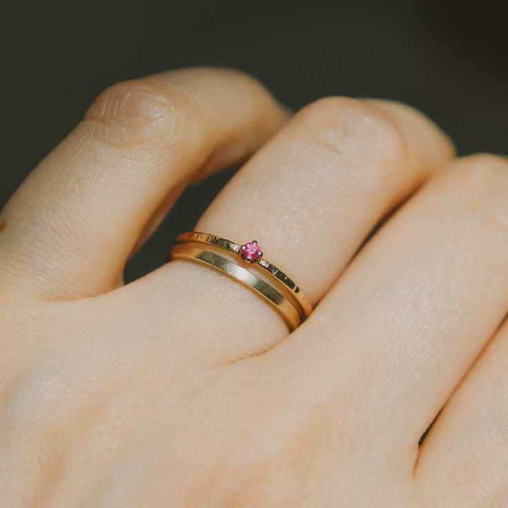 July’s birthstone - tiny ruby ring on our signature bark texture 14k yellow gold band. Dainty, delicate beauty. Perfect a lady who is not a fan of chunky gemstones, this ring won't get tangled in your clothes or hair. Match perfectly when you wear it with our dainty rings. Made of 14K yellow gold. Genuine ruby size 2 mm. Band width approximately 1.2 mm. Promise Stackable Yellow Gold Gemstone Rings, Promise Yellow Gold Stackable Rings With Gemstones, Yellow Gold Stackable Promise Rings With Gemstone, Ruby Stackable Promise Ring, Fine Jewelry Stackable Ruby Promise Ring, Gold 14k Ruby Promise Ring, Gold 14k Promise Ruby Ring, Gold Ruby Promise Ring In 14k Gold, Heirloom Style Yellow Gold Ruby Promise Ring