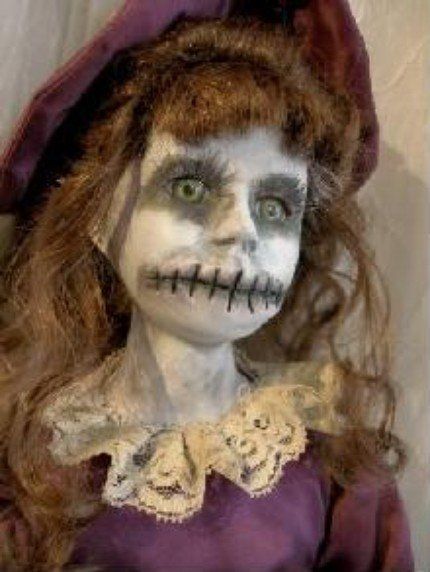 a creepy doll with long hair wearing a purple dress and white make - up on it's face