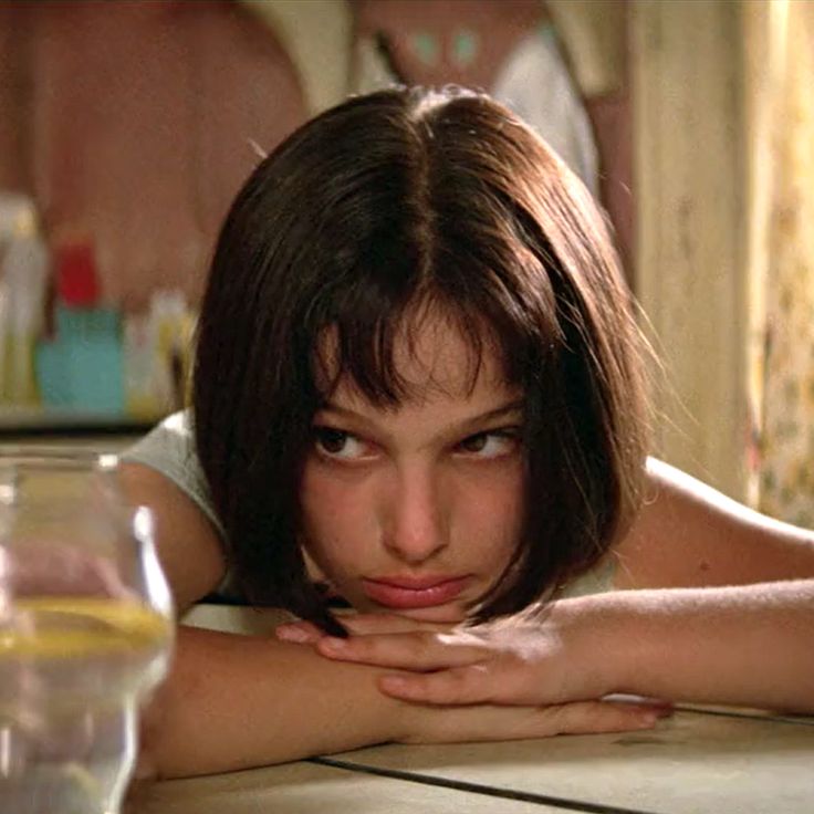 a woman laying on top of a table next to a glass of milk