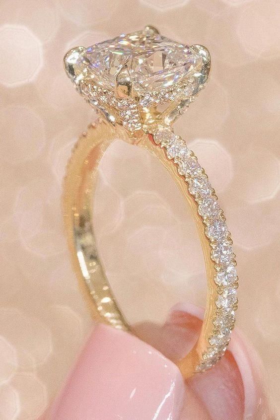 a close up of a person's hand holding a diamond ring