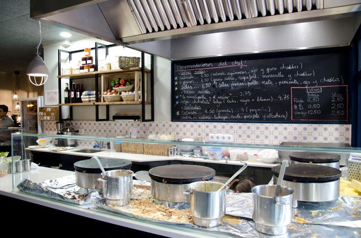 a restaurant kitchen filled with lots of food and cooking utensils on the counter