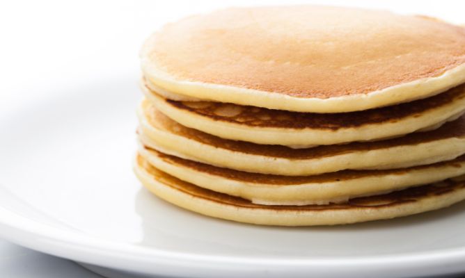 a stack of pancakes sitting on top of a white plate