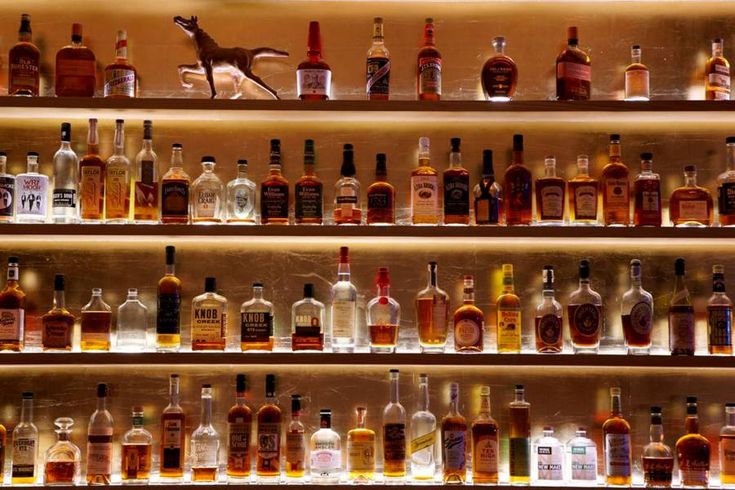 many bottles of alcohol are lined up on the wall