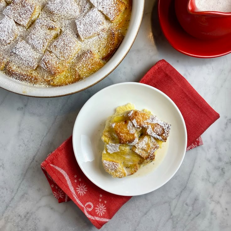 a table topped with plates and bowls filled with desserts covered in powdered sugar